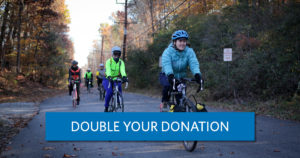 a group of women riding on a trail. A button reads "double your donation"